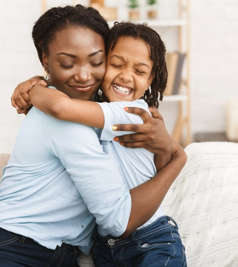 Happy black family hugging and embracing on couch Happy black family hugging and embracing on couch